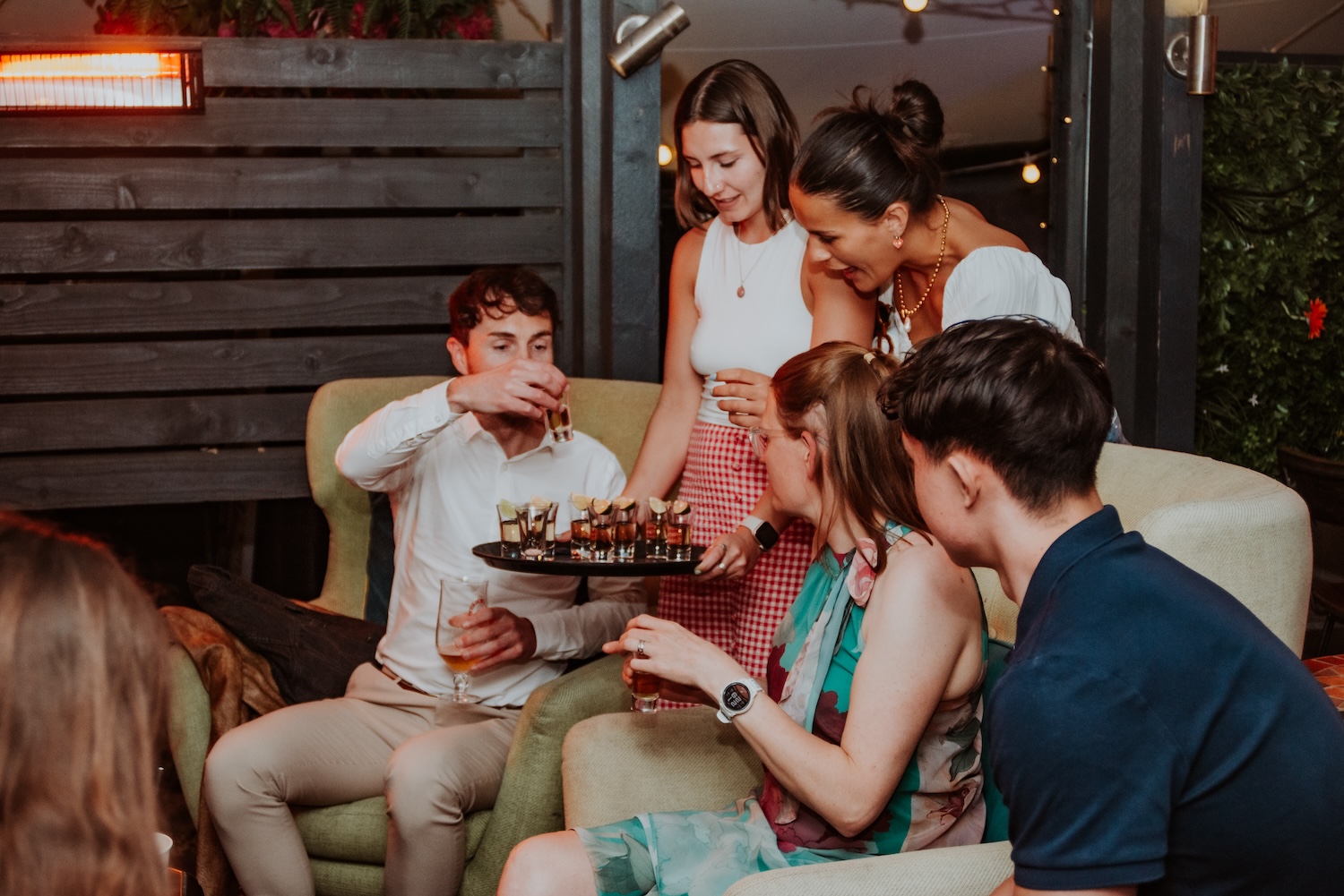 A group of friends enjoying tequila shots on a cosy outdoor terrace at The Square Club, an intimate private party venue in Bristol. The photo highlights the stylish and inviting setting, with soft lighting, comfortable seating, and attentive service, perfect for hosting exclusive gatherings or celebrations.