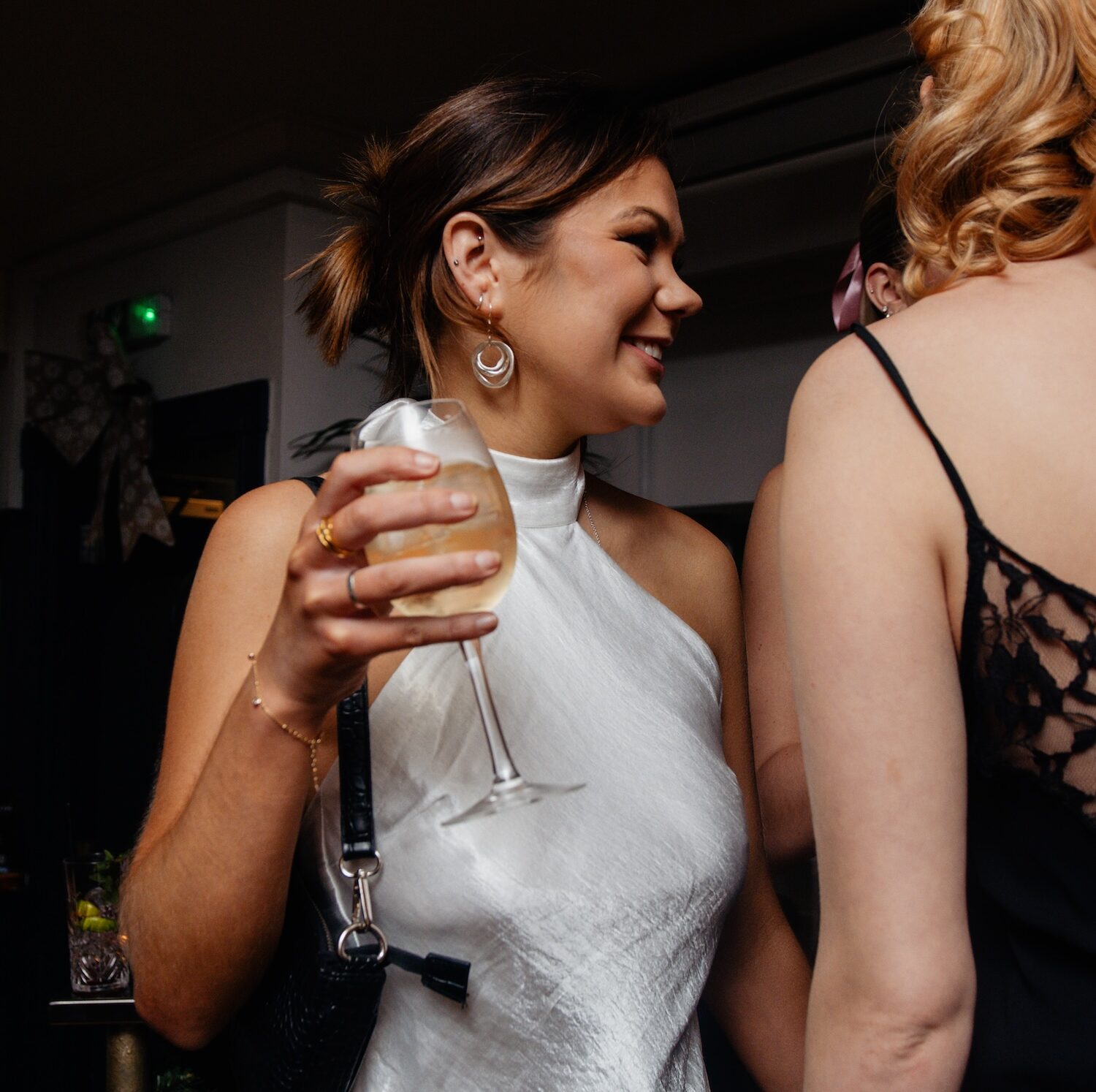 A stylish guest enjoying a glass of champagne during an exclusive event at The Square Club, a private members club known for its vibrant social atmosphere and refined gatherings.