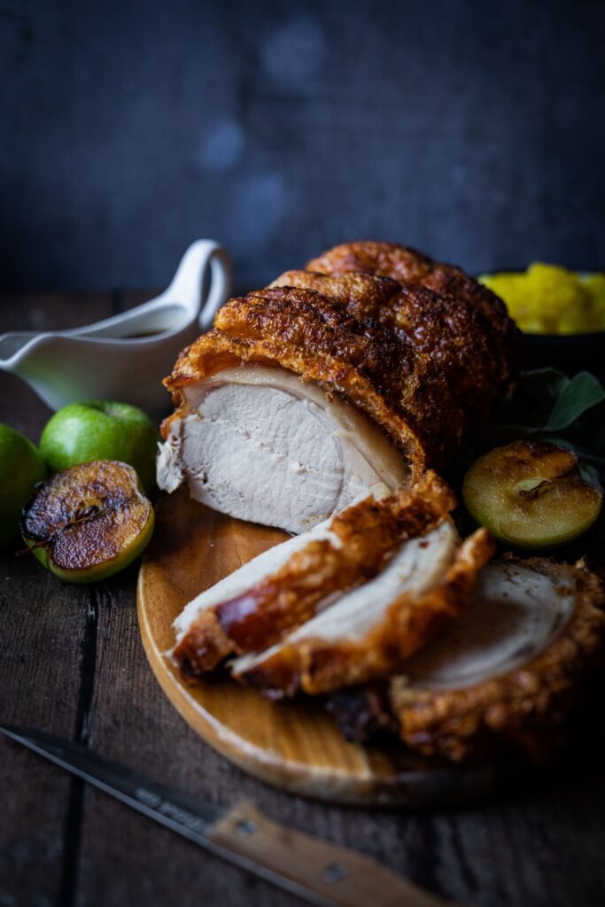 A mouthwatering close-up of The Square Club's expertly roasted pork loin with its signature crispy crackling crust. Accompanied by slow-roasted apples, fresh sage, and a side of spiced apple compote, this dish is part of our set Sunday menu, which includes all the trimmings like fluffy roast potatoes and seasonal greens. For vegetarians and vegans, the menu offers equally indulgent choices, ensuring everyone enjoys a hearty and flavour-packed Sunday roast in the heart of Clifton, Bristol.