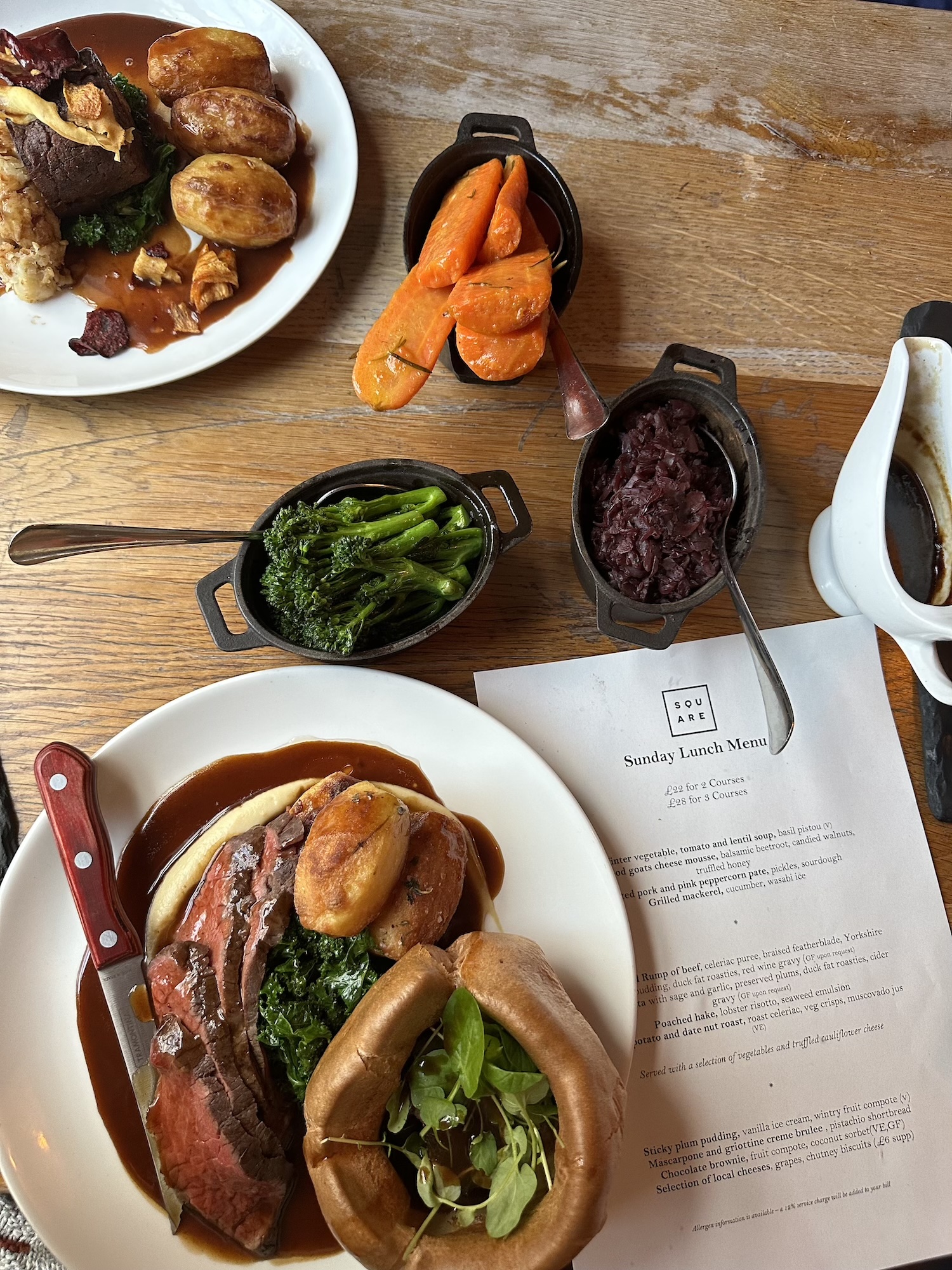 A close-up of The Square Club’s Sunday roast menu and dishes, including succulent roast beef with Yorkshire pudding and gravy, honey-glazed carrots, sautéed broccoli, and braised red cabbage. Prepared with the finest seasonal ingredients, this set Sunday menu includes vegetarian and vegan options, catering to all dietary preferences. A perfect destination for those looking for the best Sunday roast in Clifton or top-rated Sunday lunch in Bristol.