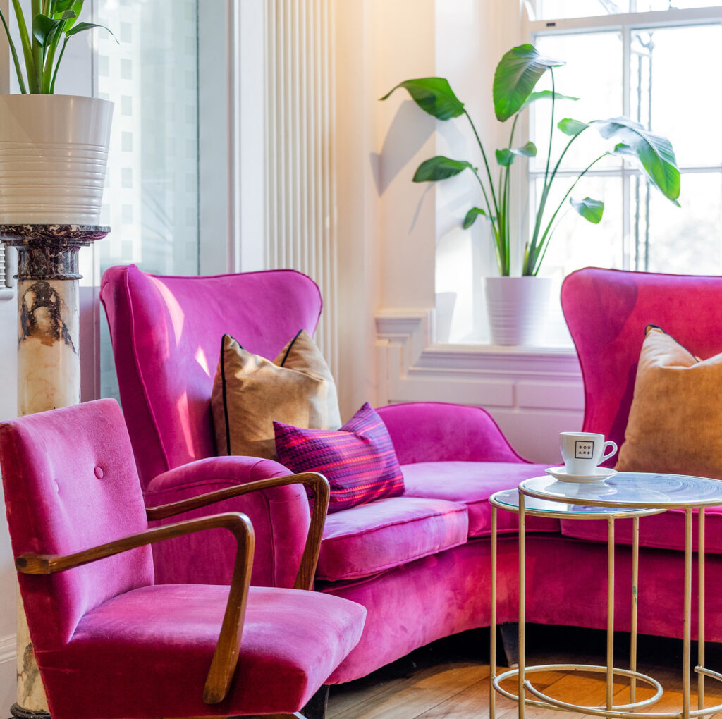 Stylish lounge area at The Square Club, featuring plush magenta seating, contemporary design, and a welcoming atmosphere for members and guests needing an informal meeting space in Bristol.