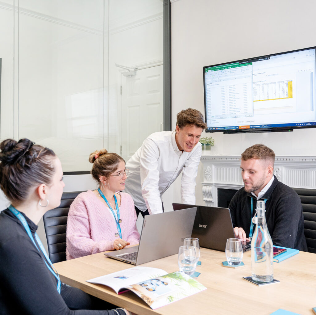 A professional team collaborating in a bright and modern meeting room at The Square Club's adjoining workspace Square Works. The Square Club is a private members club that offers sophisticated spaces equipped with advanced technology for business meetings and networking events.