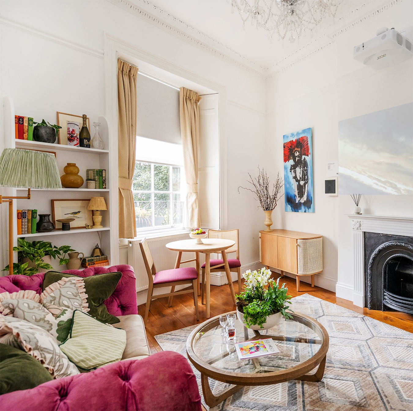 Chic living space at The Berkeley Suites in Bristol, associated with The Square Club, offering a vibrant mix of modern and vintage furniture, bold artwork, and natural light for a boutique stay experience.