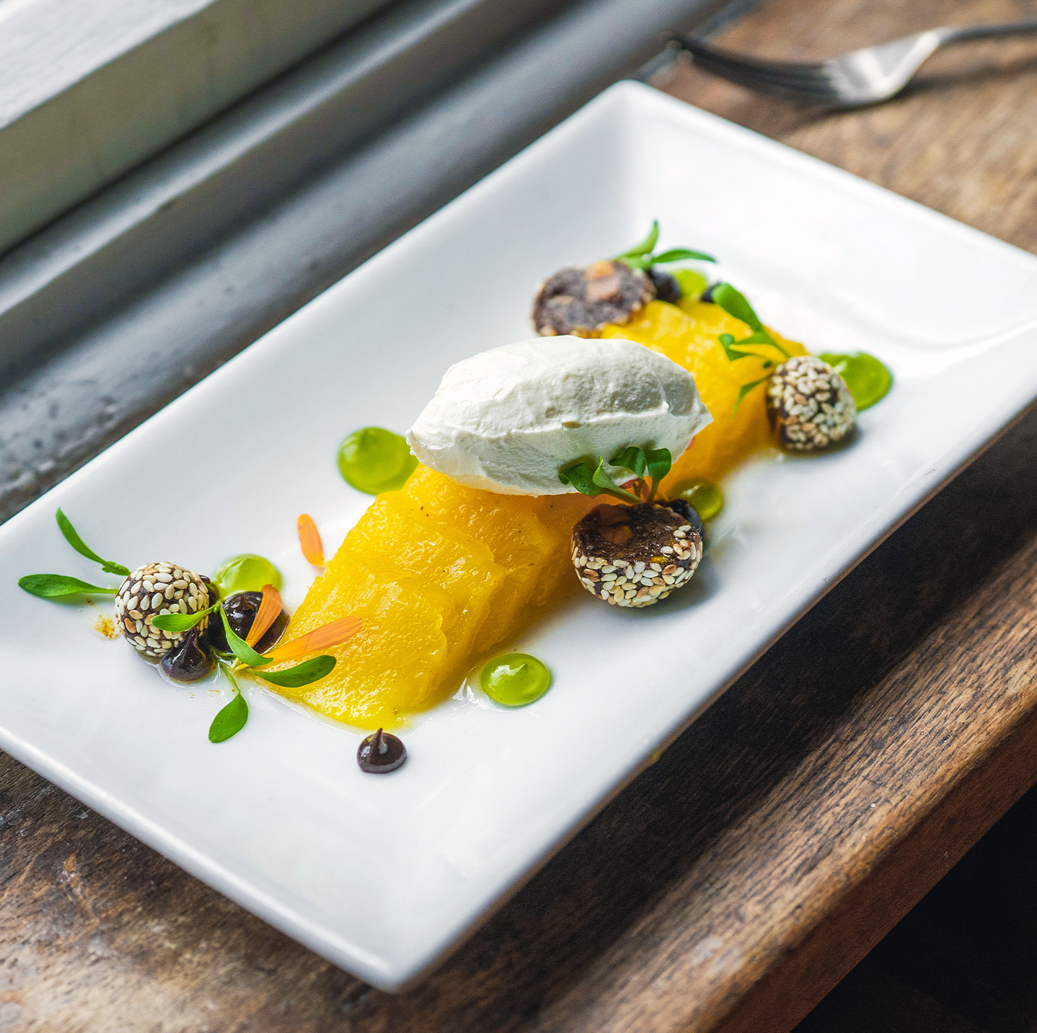 Exquisite dessert served at The Square Club, a premier private dining destination in Bristol, featuring a delicately plated tropical treat with vibrant garnishes and a modern aesthetic.