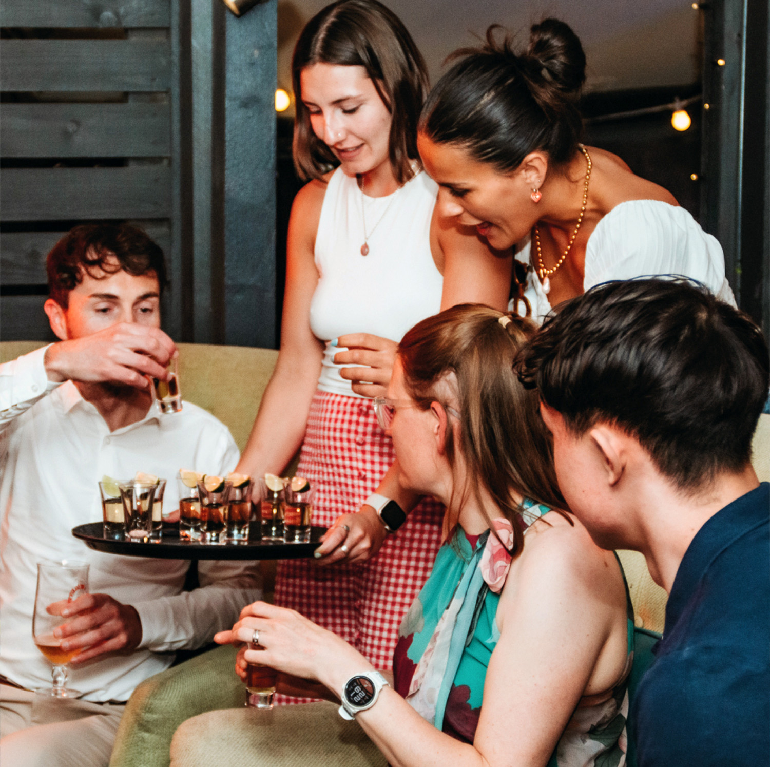 Friends enjoy signature shots at The Square Club's private members' party on the terrace, an inviting space designed for socializing and exclusive private members club events in a cosy and stylish setting.